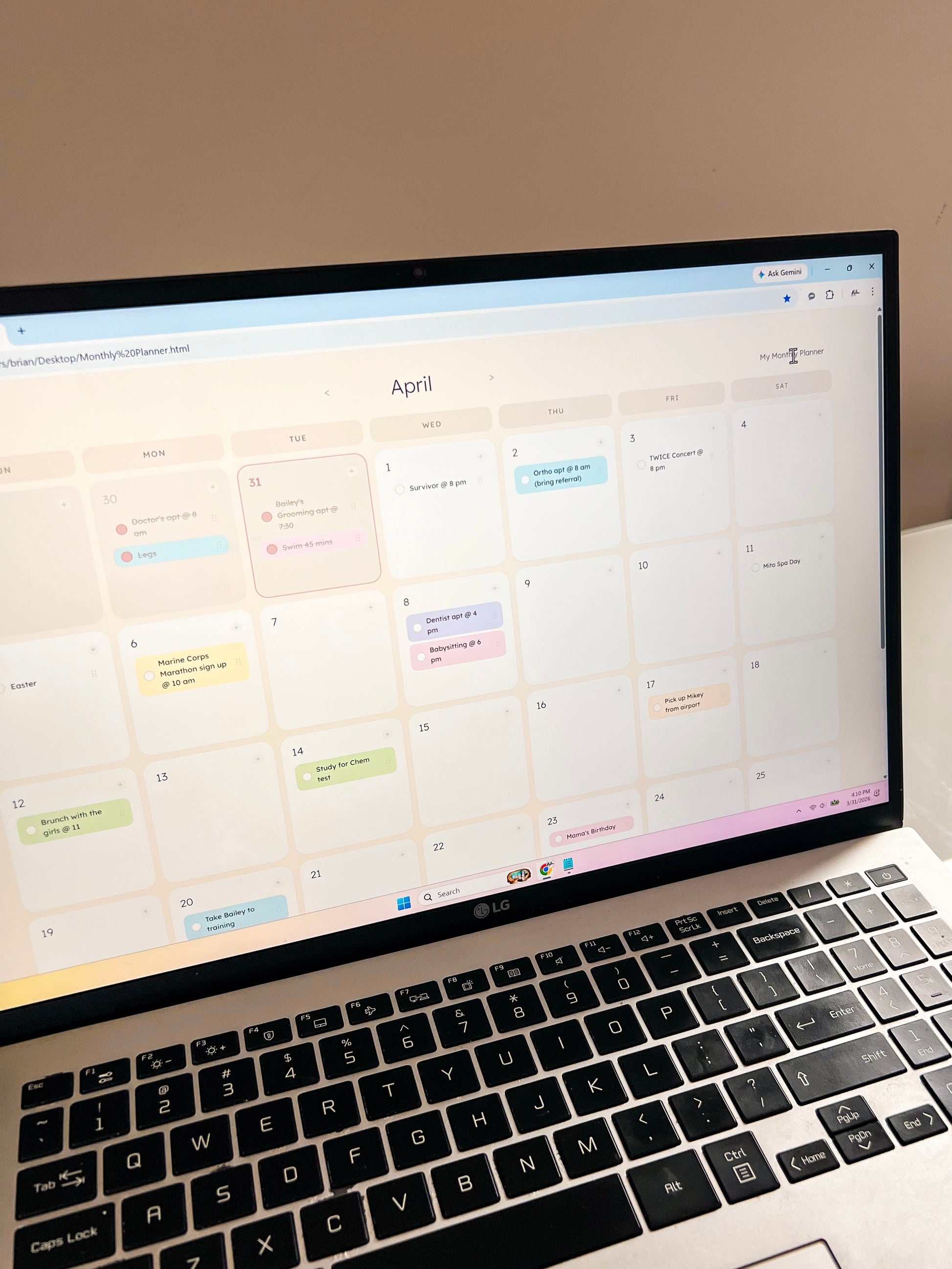 Laptop displaying a calendar with various events on a light-colored surface.