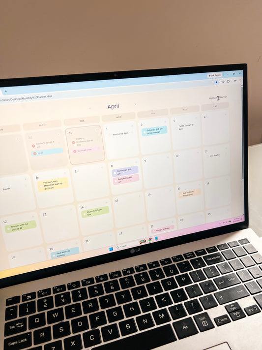 Laptop displaying a calendar with various events on a light-colored surface.